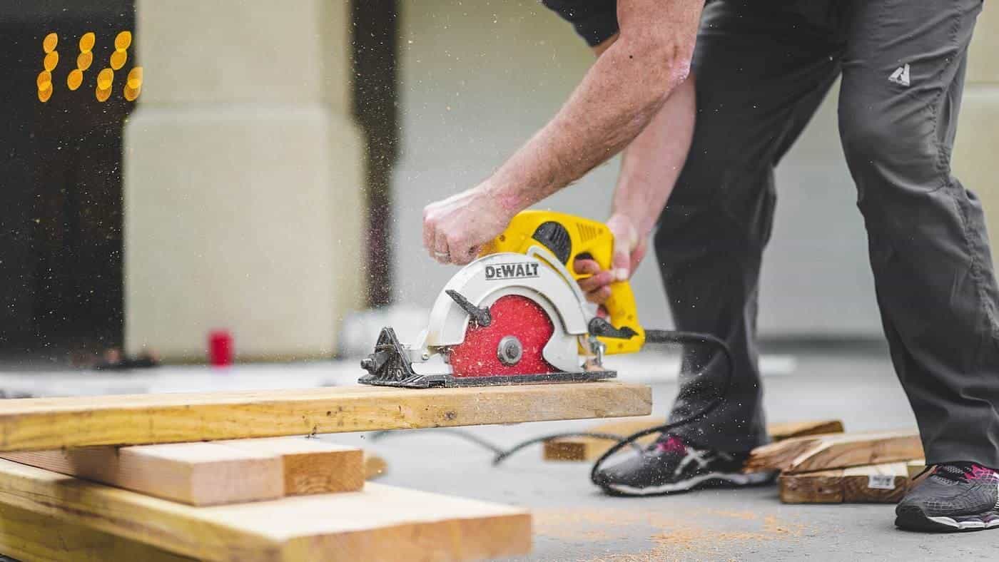 A tradesperson cutting timber with a circular saw