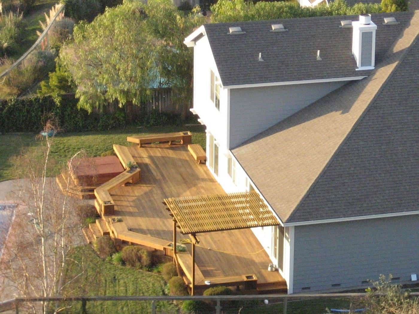 A two-level timber deck with a pergola at the back of a house